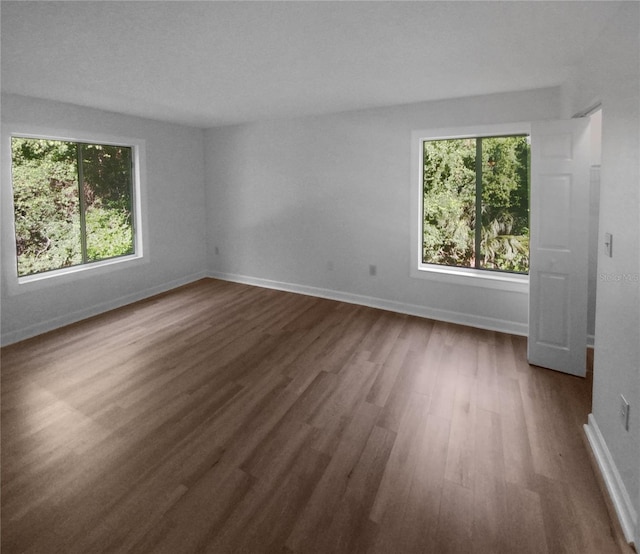 unfurnished room with dark wood-type flooring