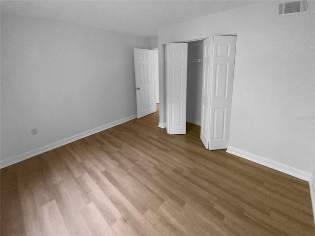 unfurnished bedroom featuring a closet and dark hardwood / wood-style floors