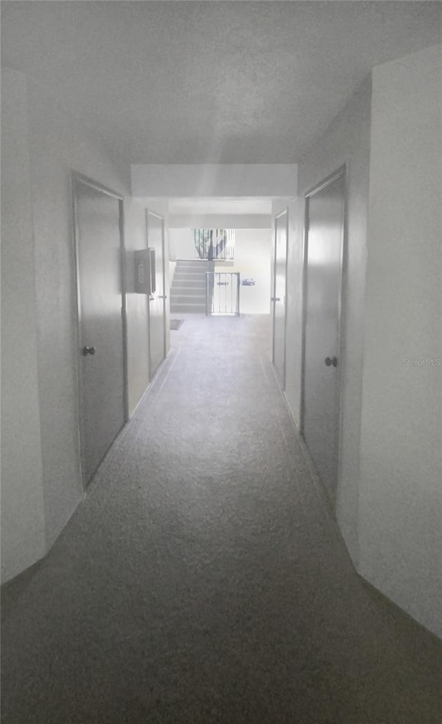 hallway featuring carpet floors and a textured ceiling