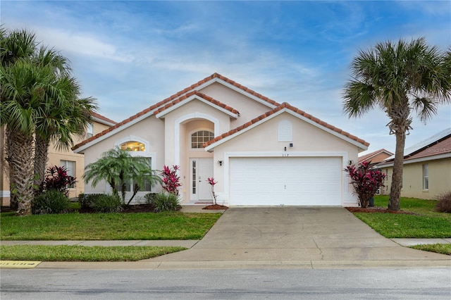 mediterranean / spanish-style home featuring a garage and a front yard