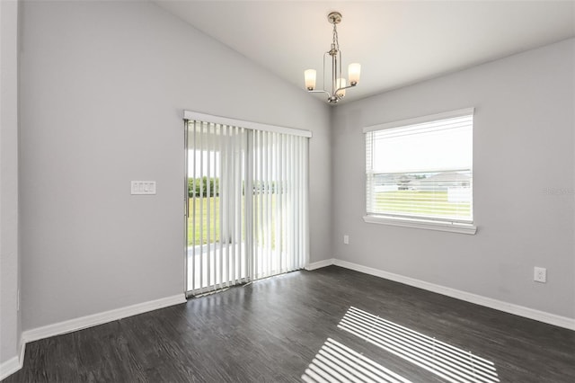 spare room featuring a chandelier, dark hardwood / wood-style floors, and vaulted ceiling