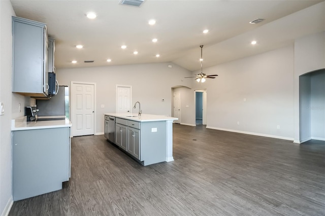 kitchen with dark wood-type flooring, stainless steel appliances, sink, a center island with sink, and ceiling fan