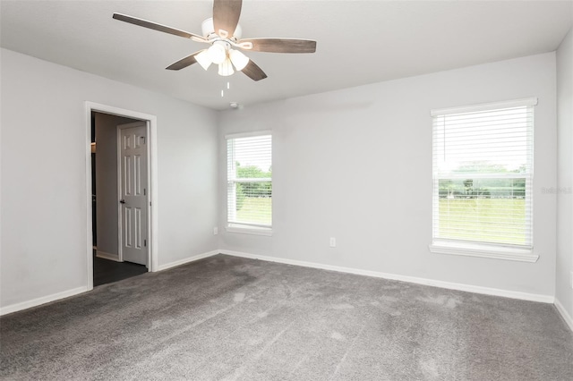 empty room with dark carpet and ceiling fan