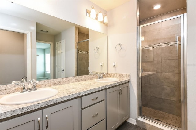 bathroom featuring walk in shower and dual bowl vanity