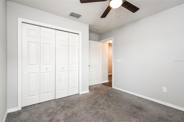 unfurnished bedroom with dark colored carpet, a closet, and ceiling fan