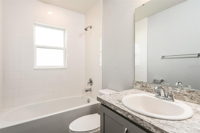 full bathroom with vanity, tiled shower / bath combo, and toilet