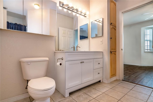 bathroom featuring vanity, wood-type flooring, toilet, ornamental molding, and ceiling fan