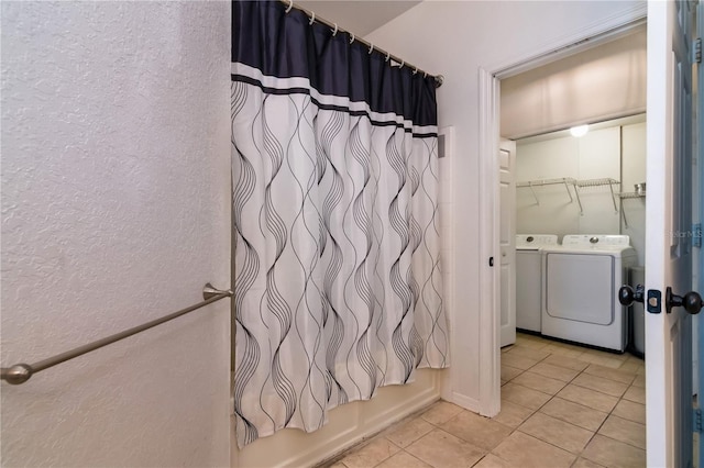 bathroom with tile patterned flooring, washer and dryer, and shower / bath combo