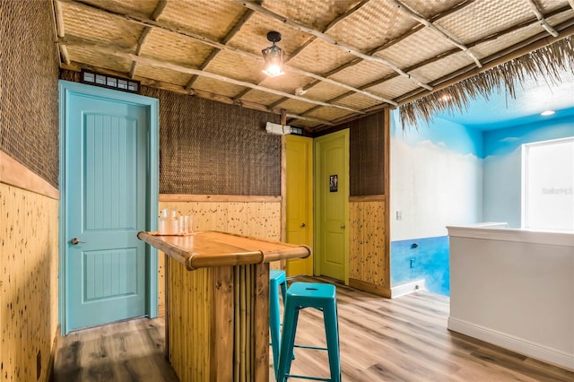 interior space featuring wood-type flooring and a kitchen breakfast bar