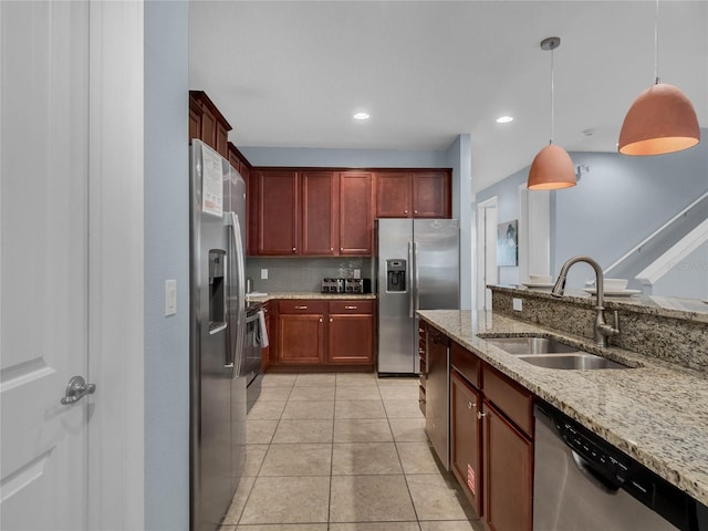 kitchen featuring stainless steel appliances, light stone counters, sink, pendant lighting, and light tile floors