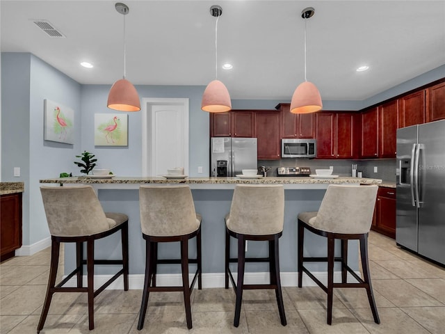 kitchen with a kitchen island, hanging light fixtures, stainless steel appliances, and light tile flooring