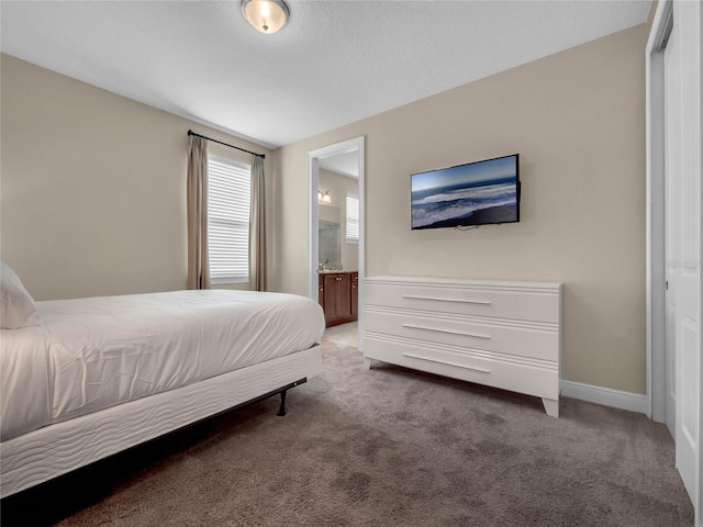 bedroom with dark carpet and ensuite bath