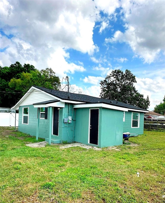 rear view of property featuring a yard