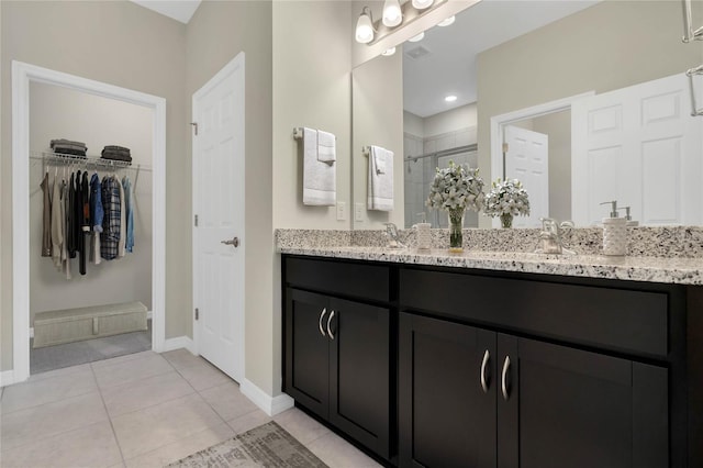 bathroom with tile patterned flooring, vanity, and a shower with shower door