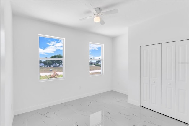 unfurnished bedroom featuring a closet, multiple windows, ceiling fan, and light tile floors