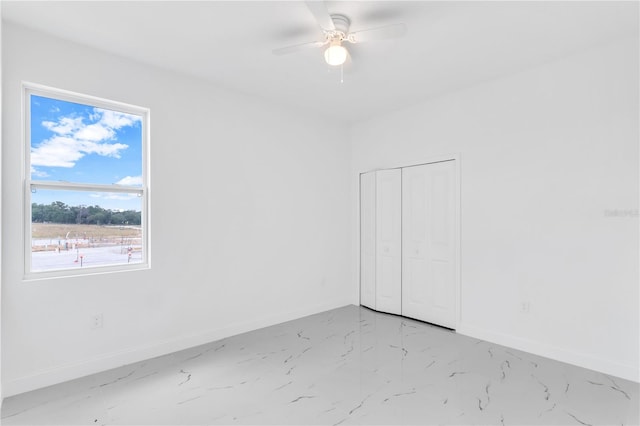 tiled spare room featuring ceiling fan