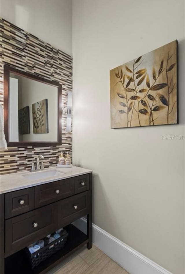 bathroom with tasteful backsplash, vanity, and tile floors