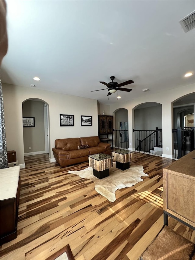 living room featuring wood-type flooring and ceiling fan