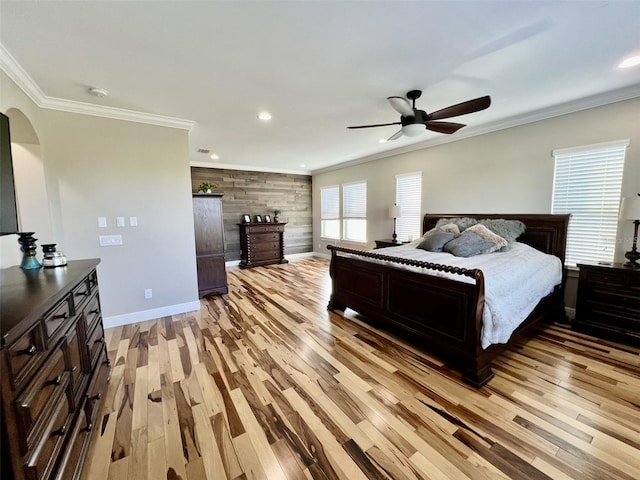 bedroom featuring crown molding, light hardwood / wood-style flooring, ceiling fan, and wood walls