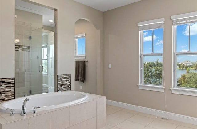 bathroom with a healthy amount of sunlight, shower with separate bathtub, and tile floors