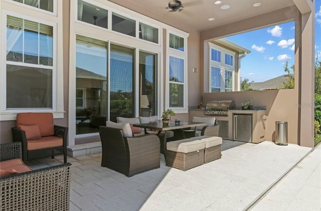 view of patio / terrace with exterior kitchen, ceiling fan, area for grilling, and an outdoor hangout area