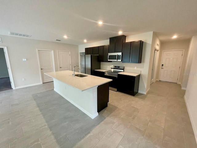 kitchen featuring appliances with stainless steel finishes, a kitchen island with sink, and sink