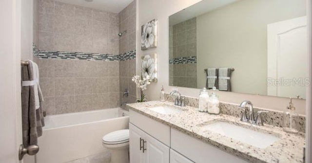 full bathroom featuring vanity, toilet, and tiled shower / bath combo