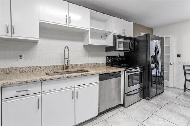 kitchen featuring sink, stainless steel appliances, light tile patterned floors, decorative backsplash, and white cabinets