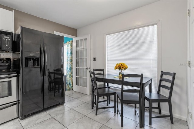 dining space featuring french doors, light tile patterned flooring, and a healthy amount of sunlight