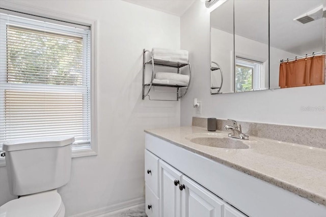 bathroom with curtained shower, vanity, and toilet