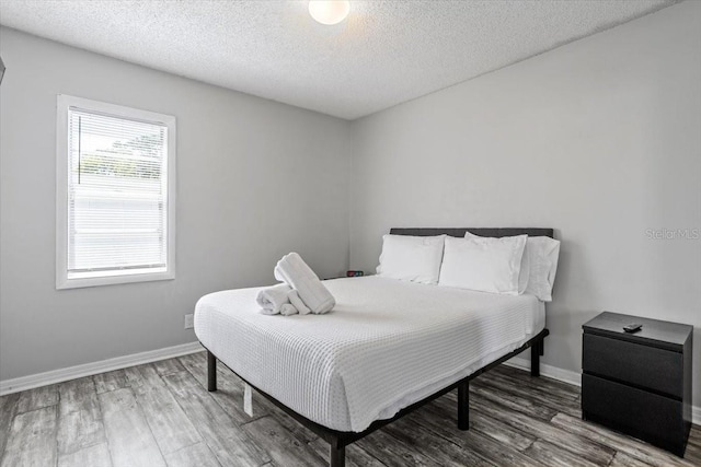 bedroom featuring hardwood / wood-style floors and a textured ceiling