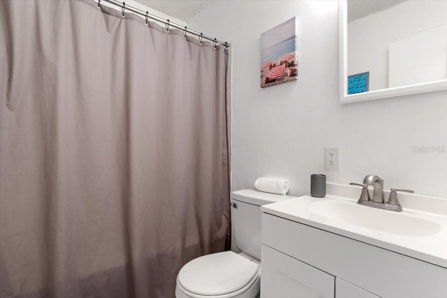 bathroom featuring vanity, a textured ceiling, and toilet