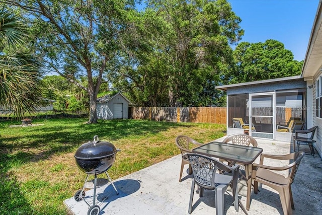 view of patio / terrace with a fire pit, a sunroom, and a shed