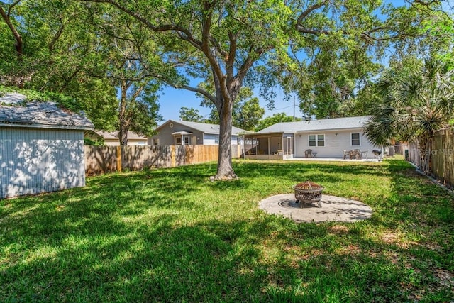 view of yard with a patio area, a sunroom, and a fire pit