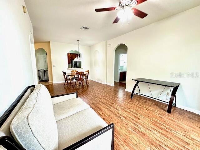 living room with ceiling fan and hardwood / wood-style flooring