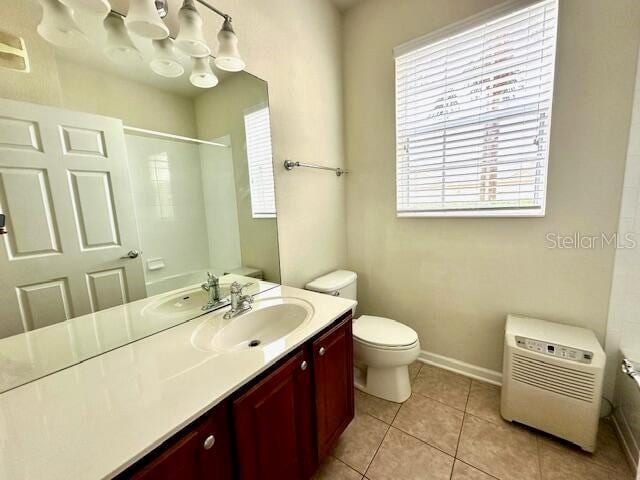 bathroom with plenty of natural light, vanity, toilet, and tile floors