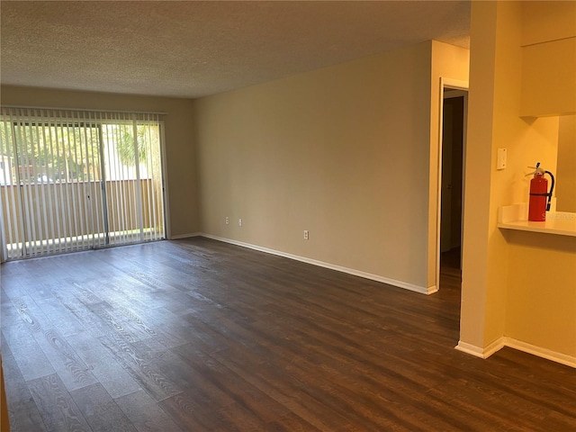 empty room featuring dark hardwood / wood-style floors and a textured ceiling