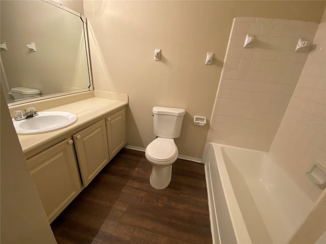 full bathroom featuring wood-type flooring, washtub / shower combination, large vanity, and toilet