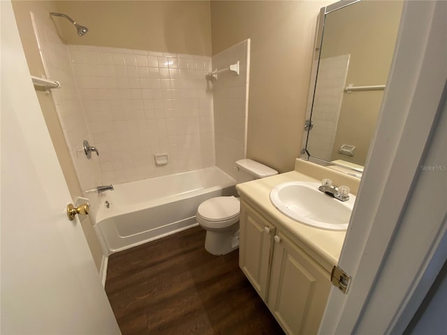 full bathroom featuring vanity, wood-type flooring, tiled shower / bath combo, and toilet