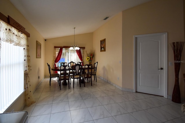 dining area with lofted ceiling, light tile floors, and a chandelier