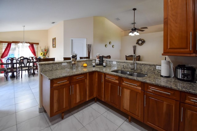 kitchen with stone countertops, sink, kitchen peninsula, and light tile floors