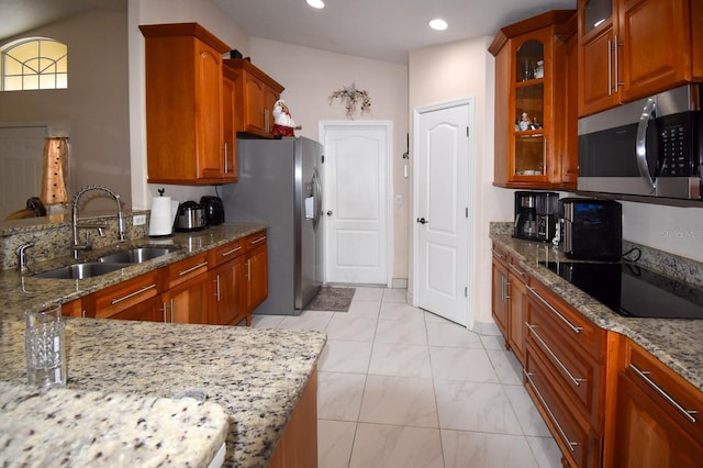 kitchen featuring light tile floors, sink, stainless steel appliances, vaulted ceiling, and light stone countertops