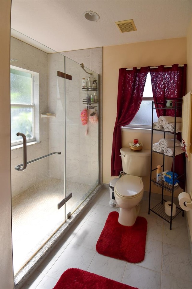 bathroom with a shower with shower door, toilet, and tile floors