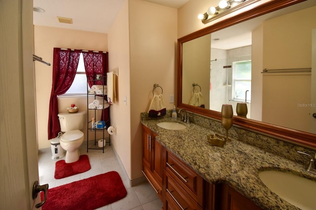 bathroom featuring tile flooring, double vanity, and toilet