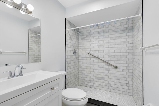 bathroom featuring tiled shower, vanity, and toilet