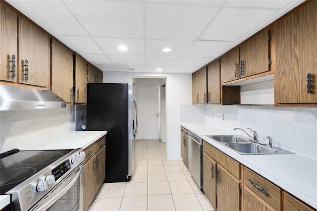 kitchen featuring a paneled ceiling, light tile patterned floors, sink, and appliances with stainless steel finishes