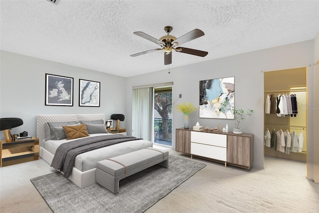 bedroom featuring light carpet, a closet, ceiling fan, and a textured ceiling