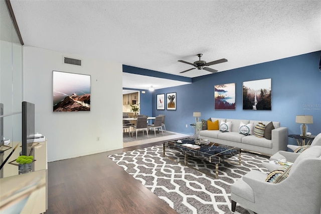 living room featuring hardwood / wood-style floors, a textured ceiling, and ceiling fan