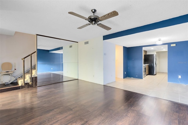 unfurnished room with ceiling fan, light hardwood / wood-style floors, and a textured ceiling