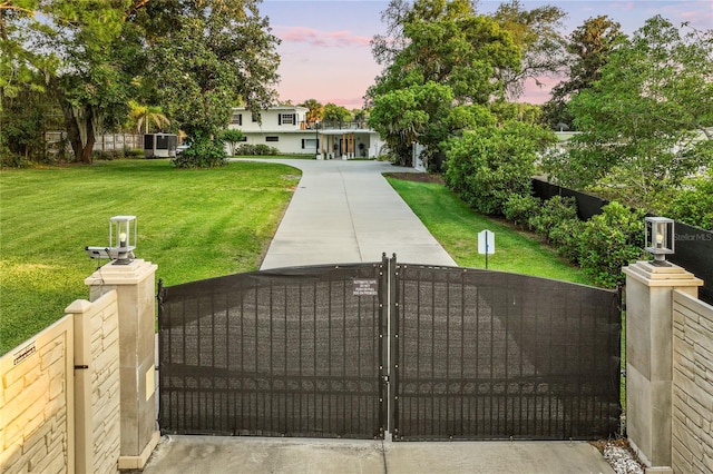 gate at dusk featuring a yard